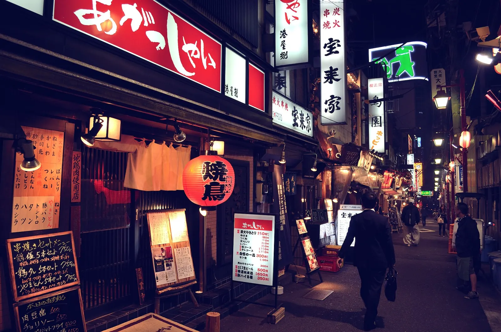Lanterns and noren along a Tokyo izakaya lane after dark