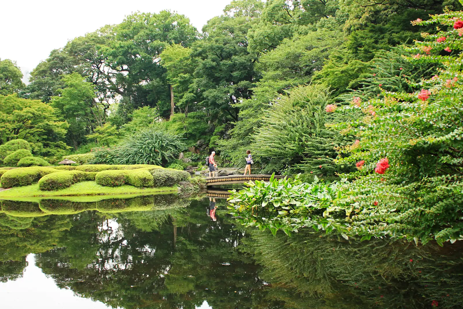 Walkers crossing a small bridge in the Ninomaru garden