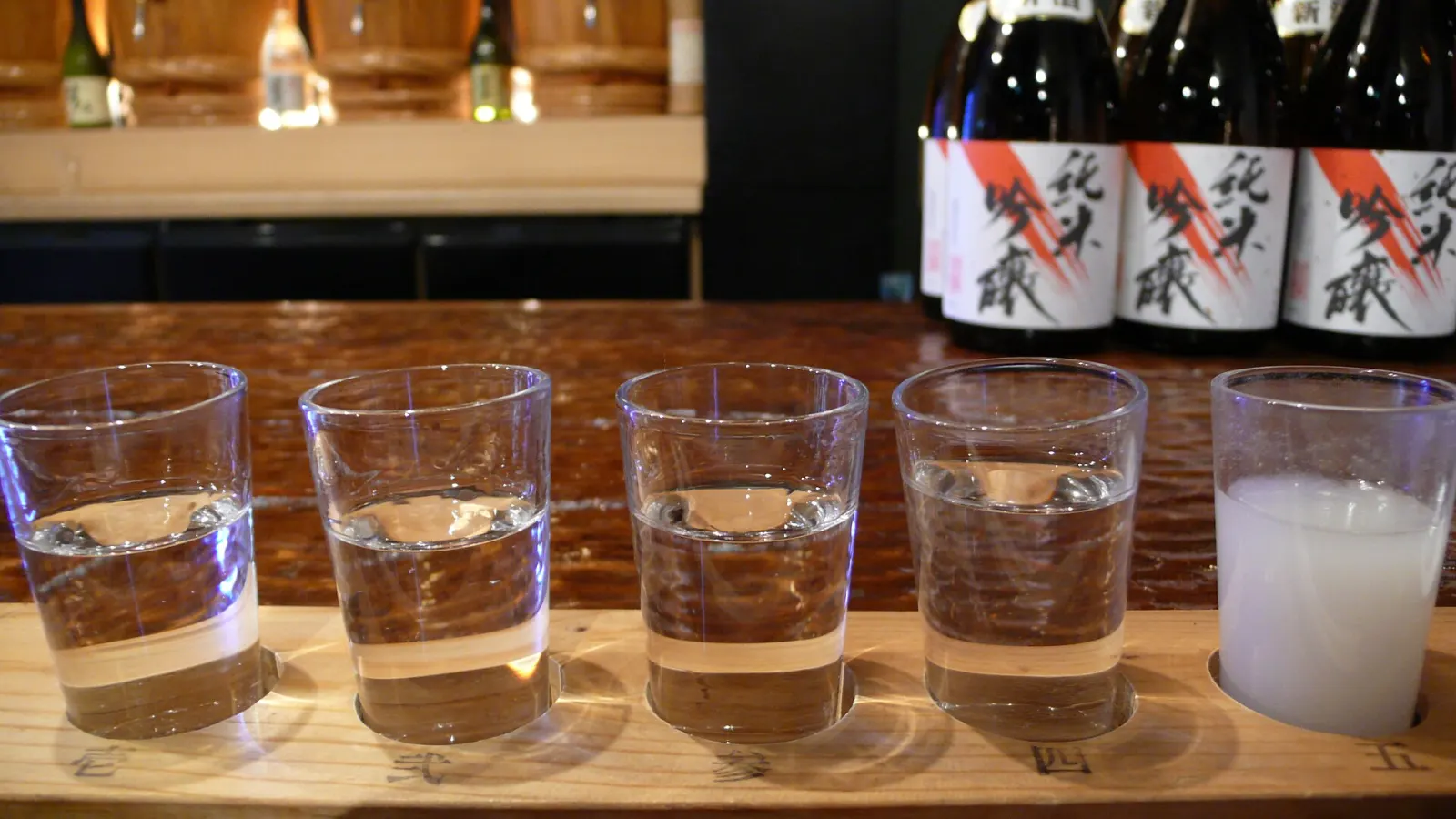 A flight of five sakes in a wooden tray