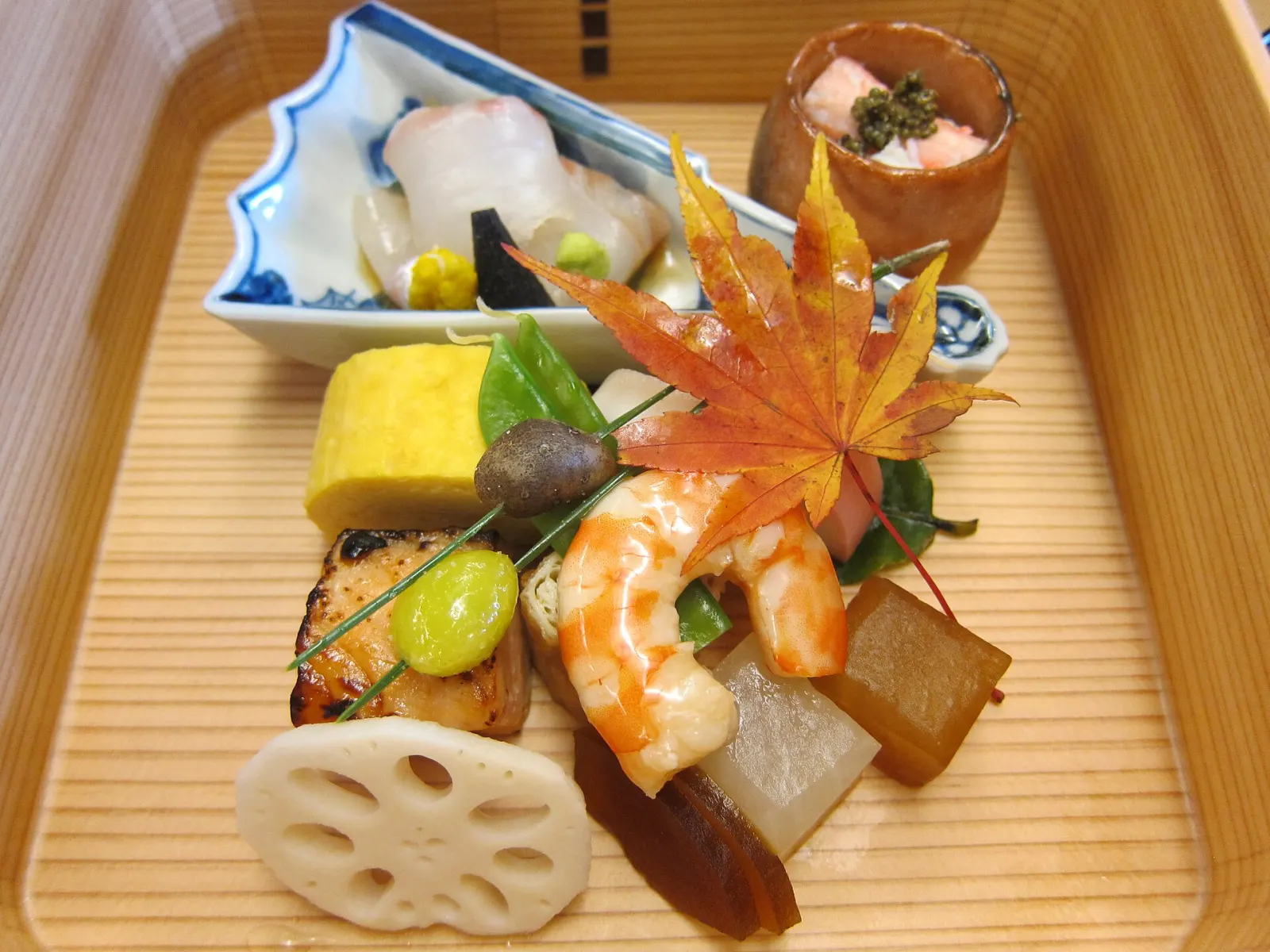 An autumn kaiseki tray, a red maple leaf on top