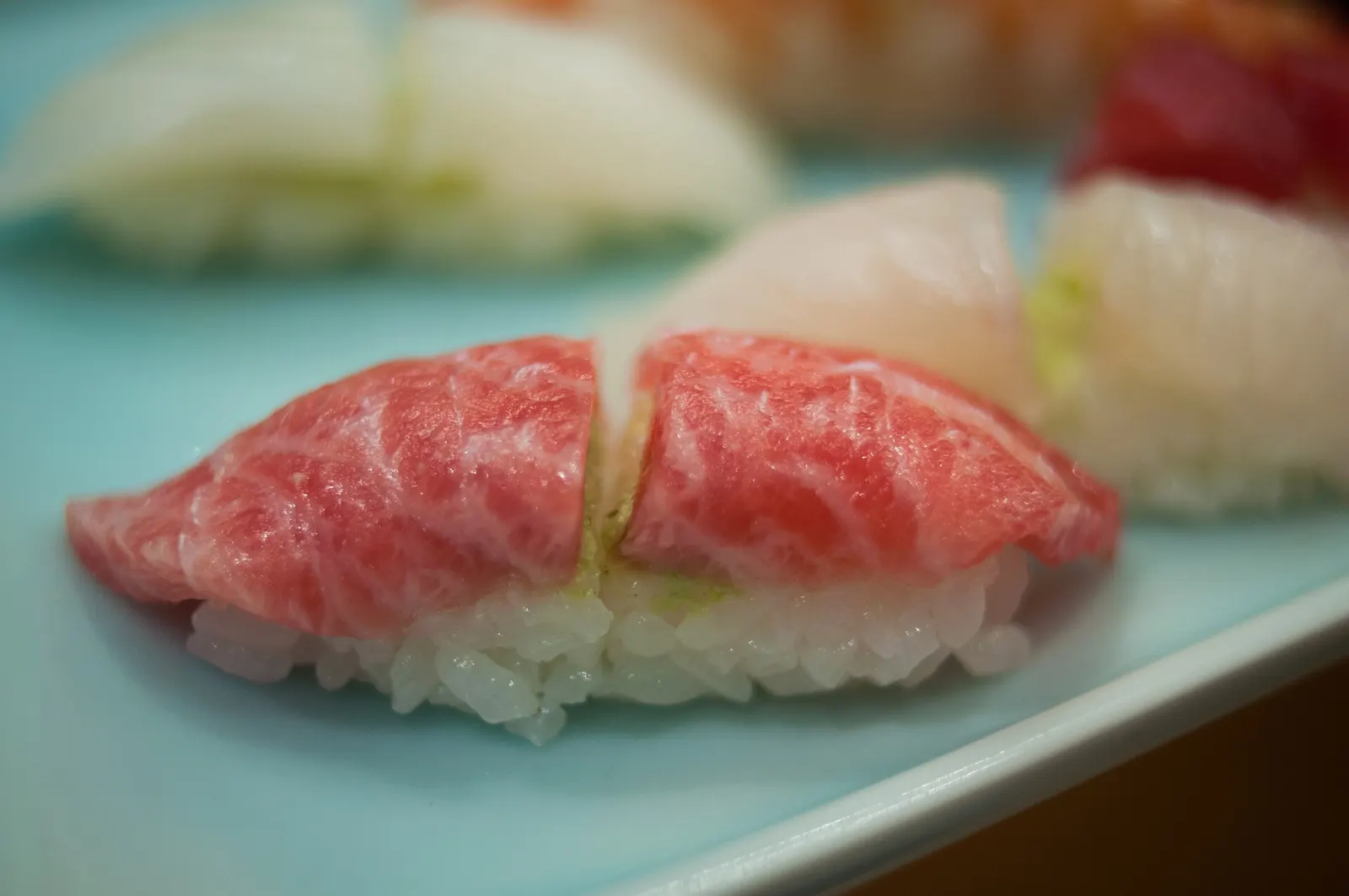 Fatty tuna nigiri on a pale blue plate