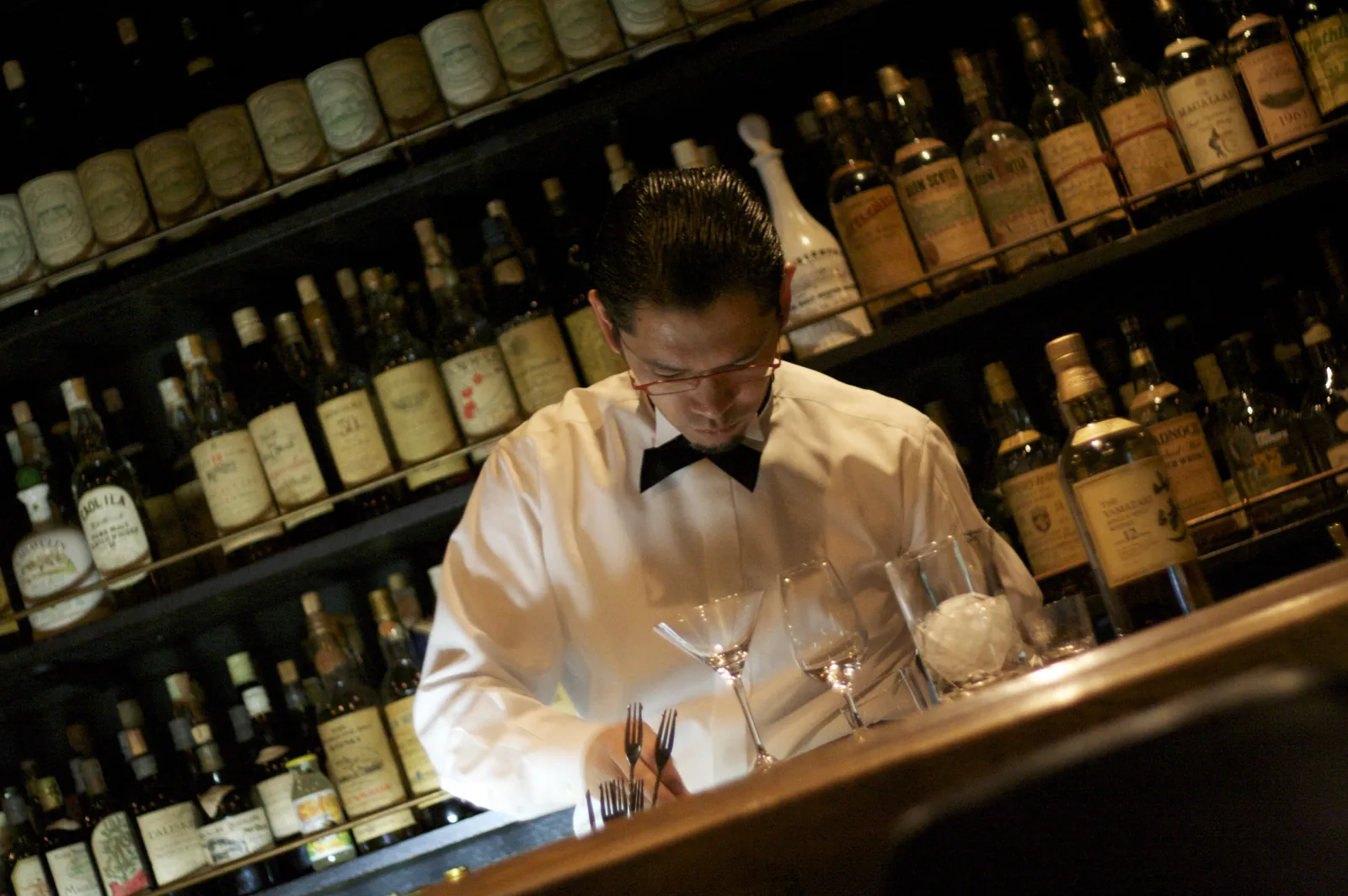 A bartender at work in front of the back bar