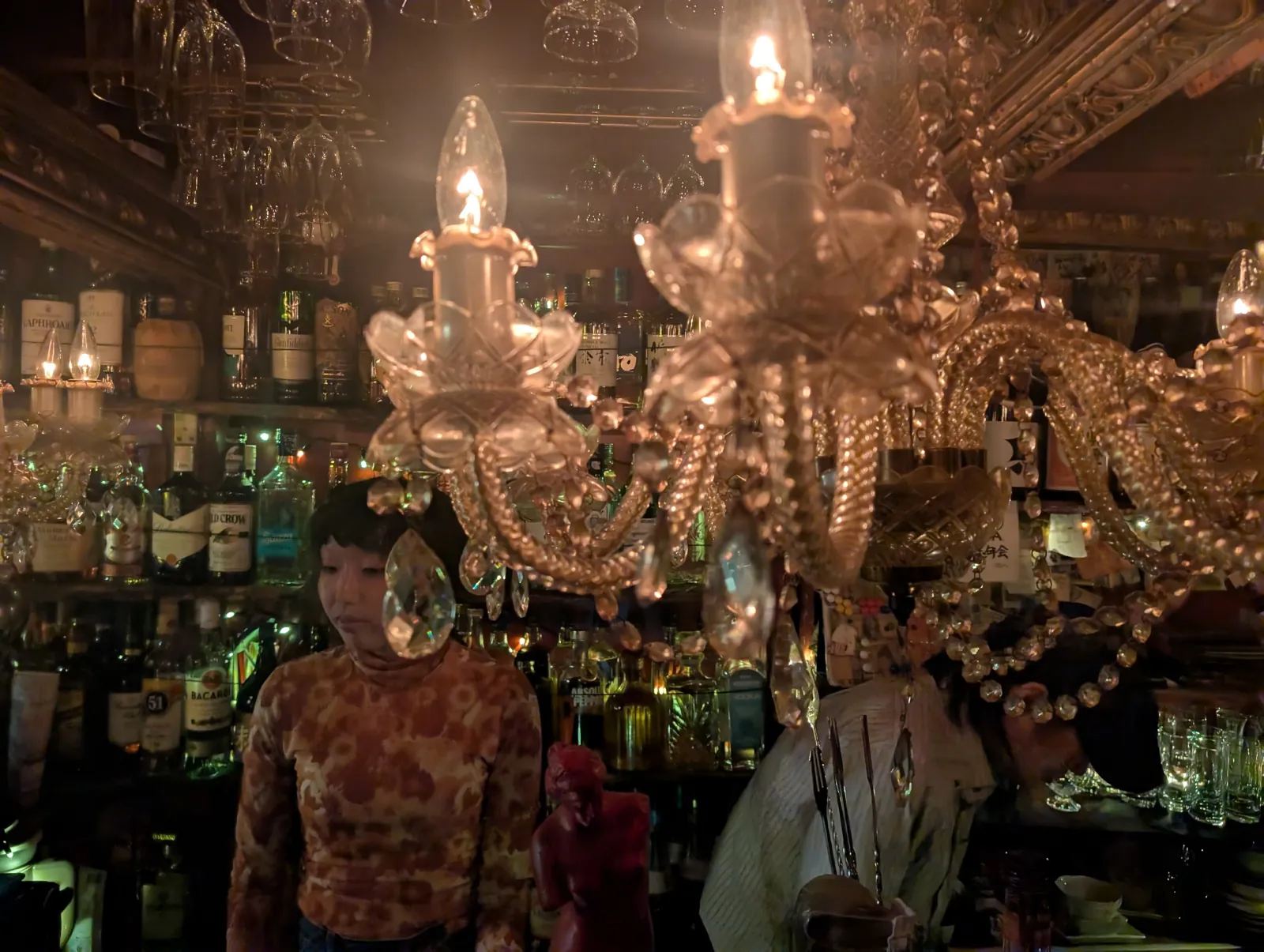 Candlelight and a chandelier over a tiny Tokyo bar