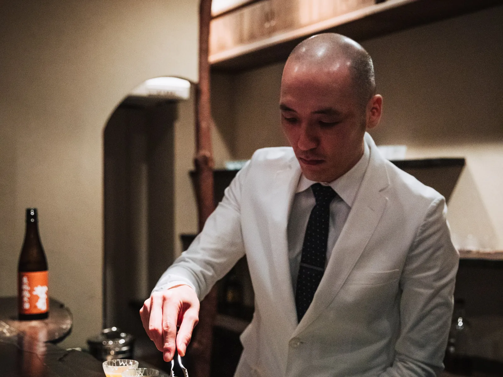 A bartender preparing drinks at a quiet Tokyo counter