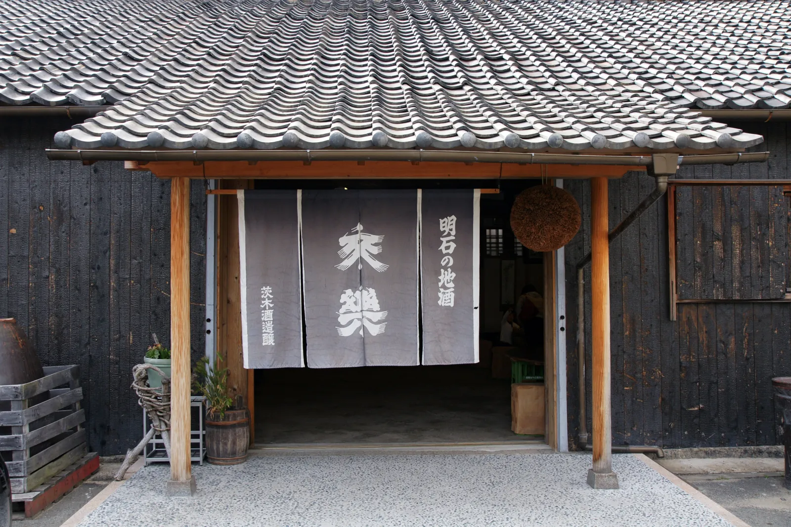 A sake brewery's entrance, with noren and cedar ball