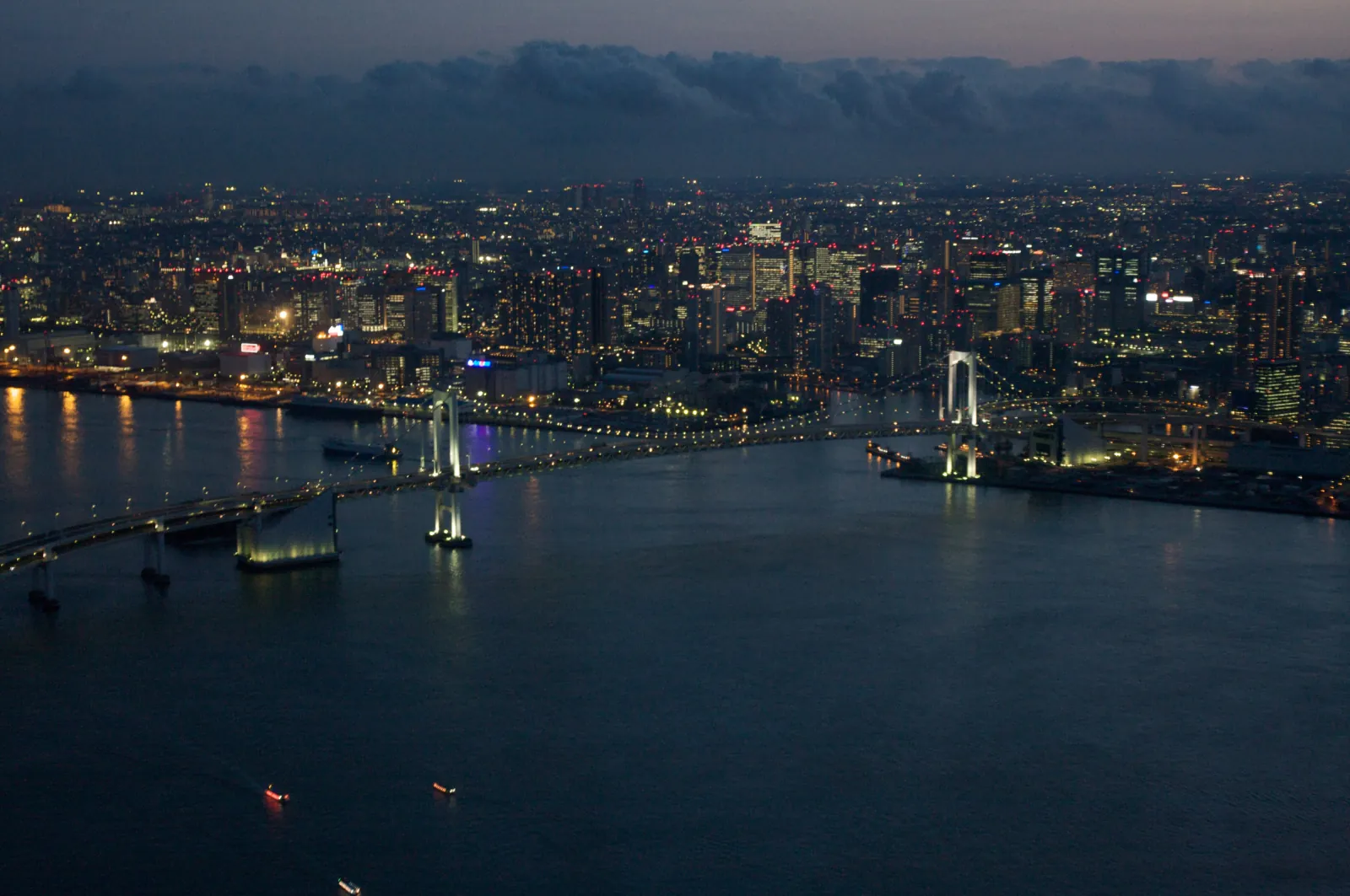 Rainbow Bridge lit up over Tokyo Bay at dusk