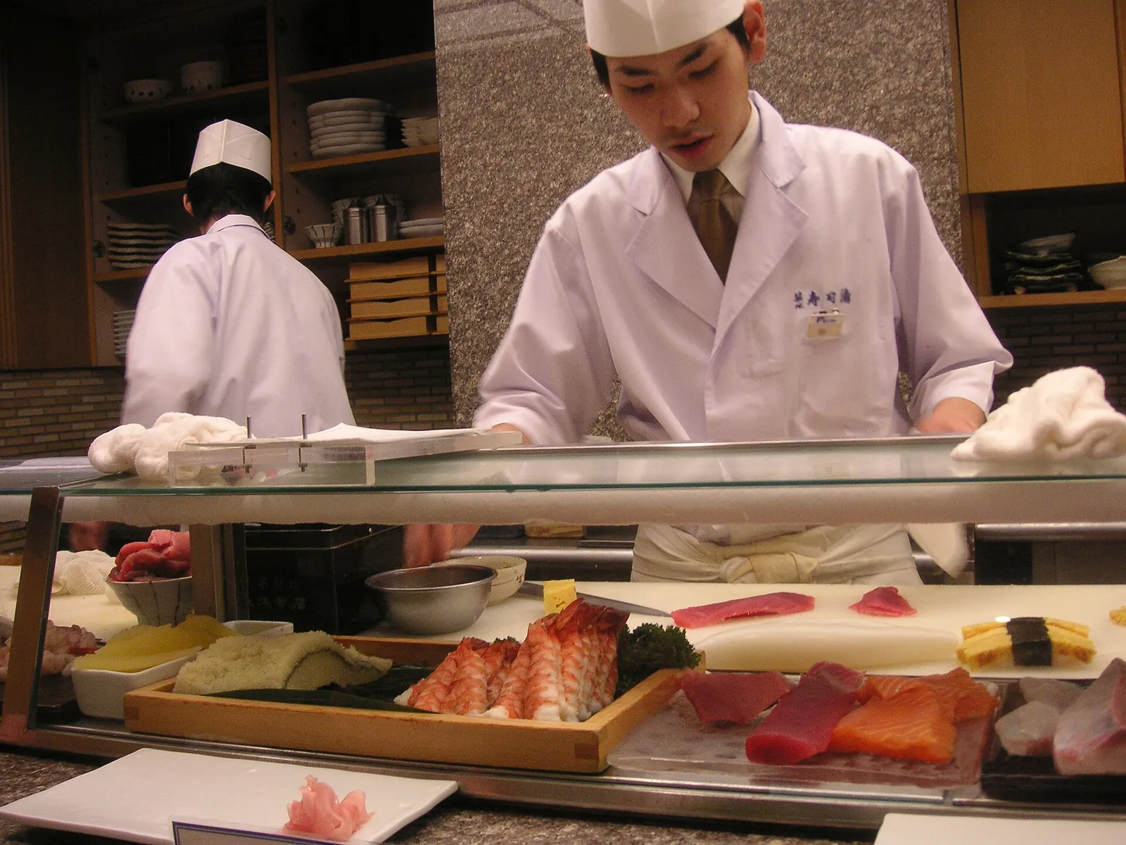 A sushi chef at work behind the fish case